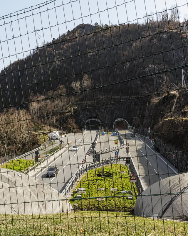 Road tunnel entrances seen through a fence