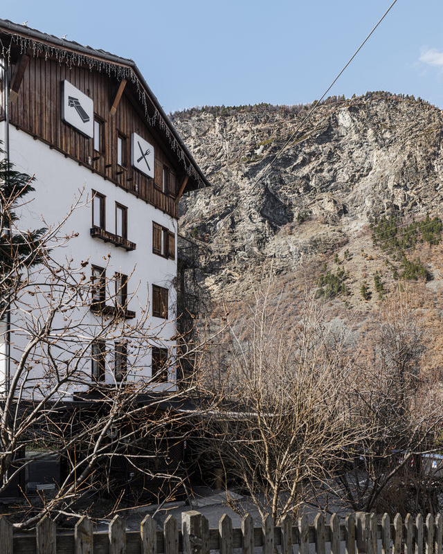 House façade with a power line and mountain in the background